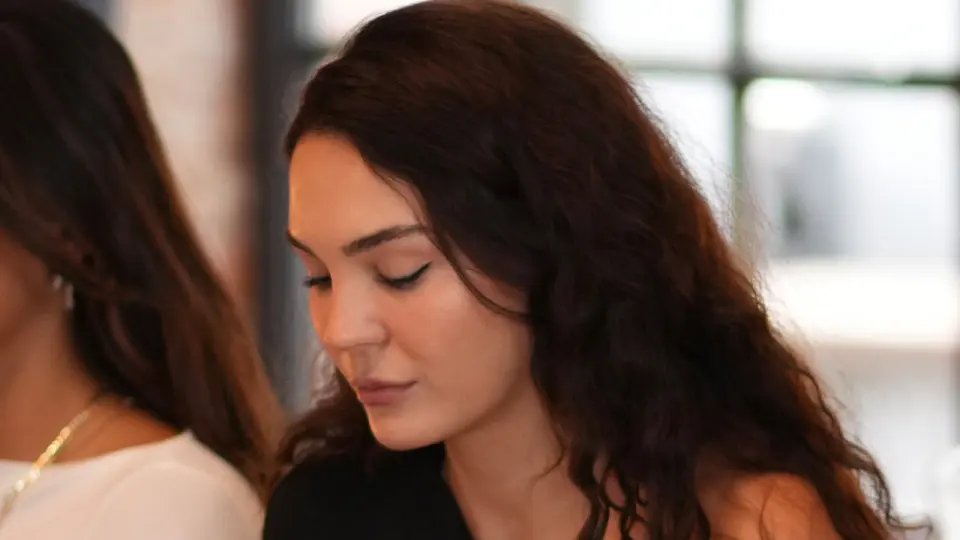 Okuma provasından: uzun koyu saçlı bir kadın oyuncu senaryoya bakıyor.